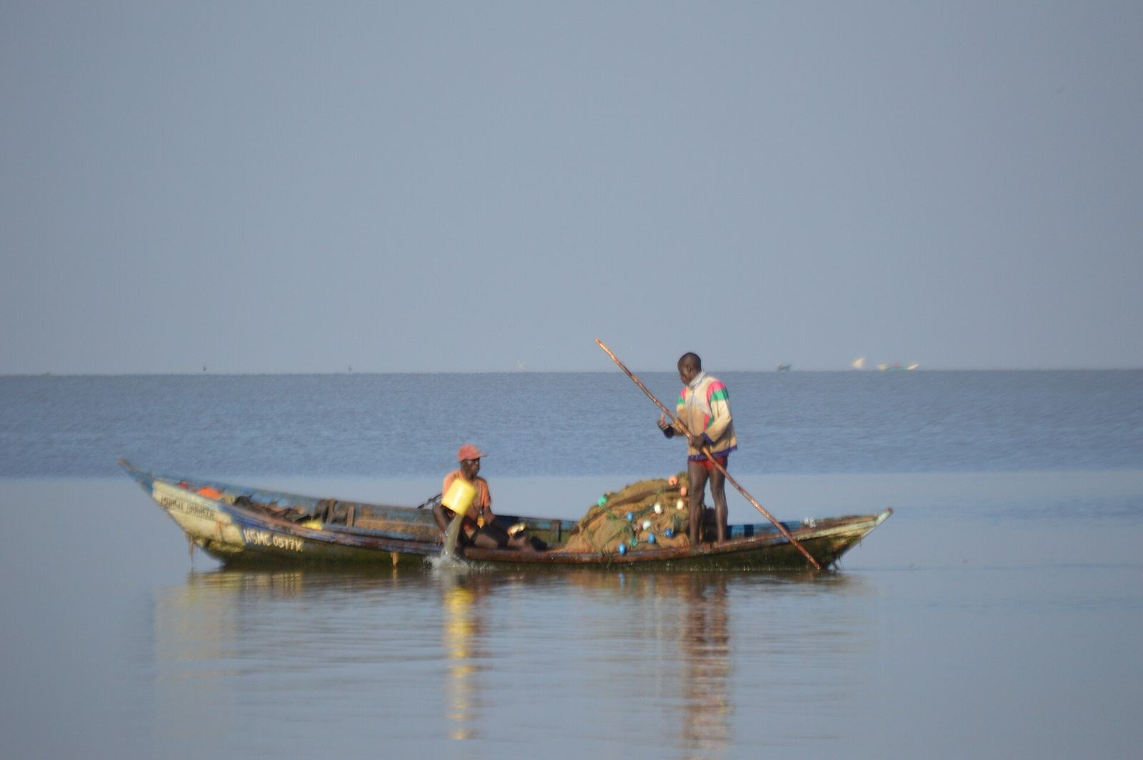 A fisherman launching his boat at the shore